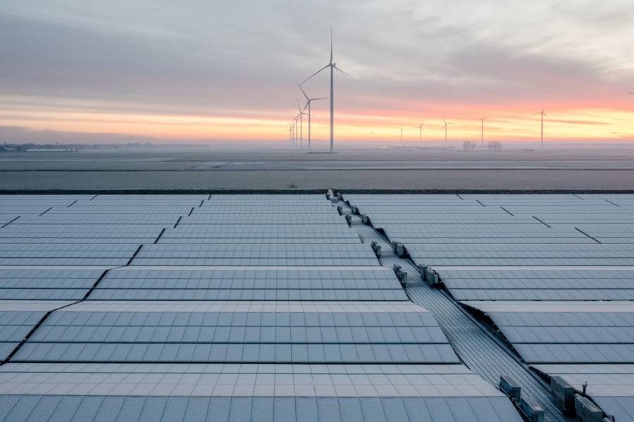 Solar panels and wind turbines at dawn